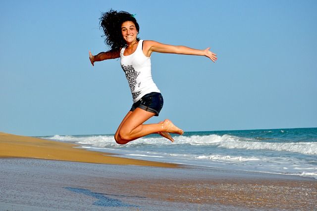 Dívka ve výskoku na pláži u moře